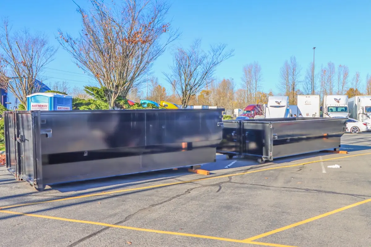 Professional dumpster rental service with roll-off container on residential driveway in New Hyde Park